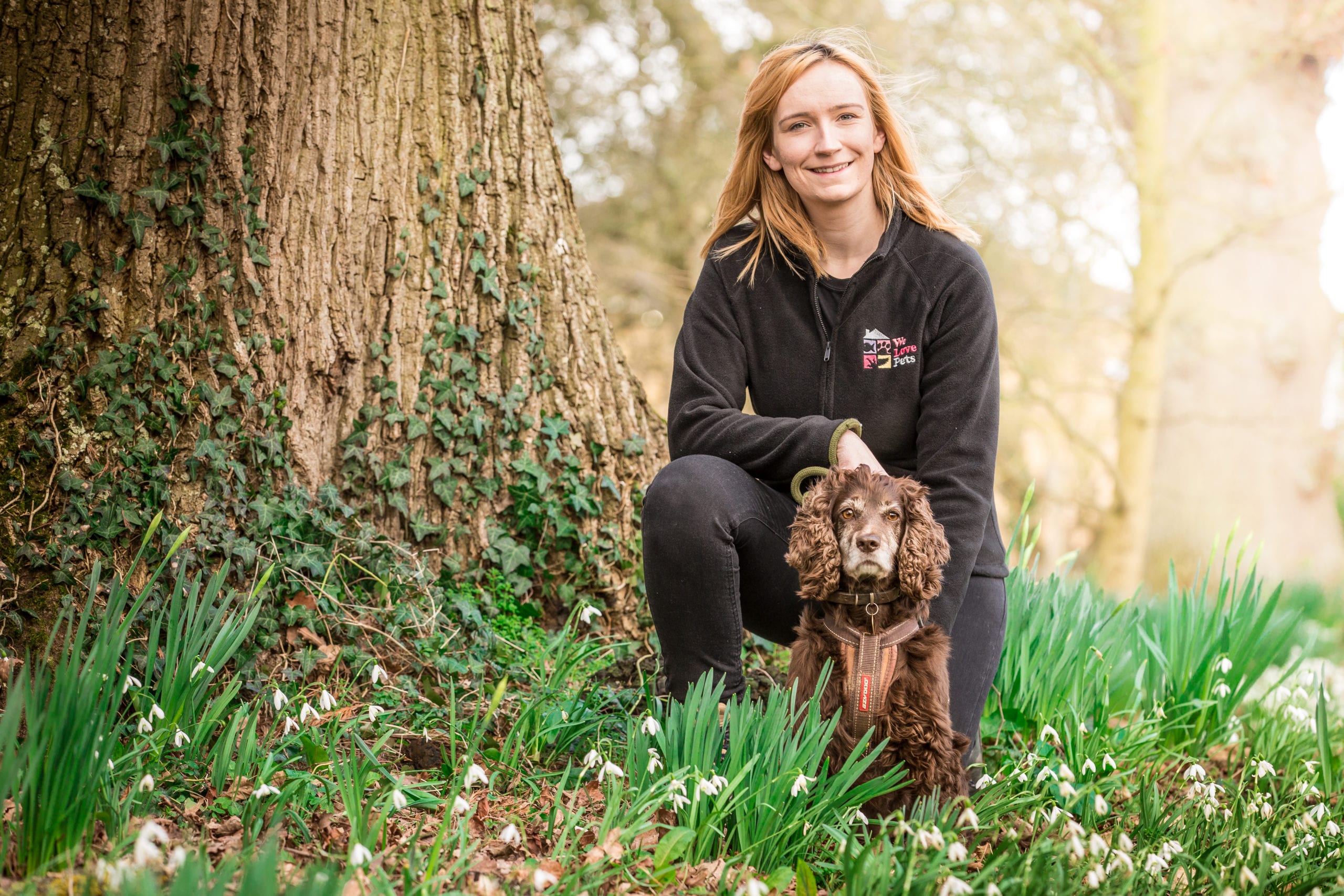 Shannon from We Love Pets Ascot kneeling with a small dog