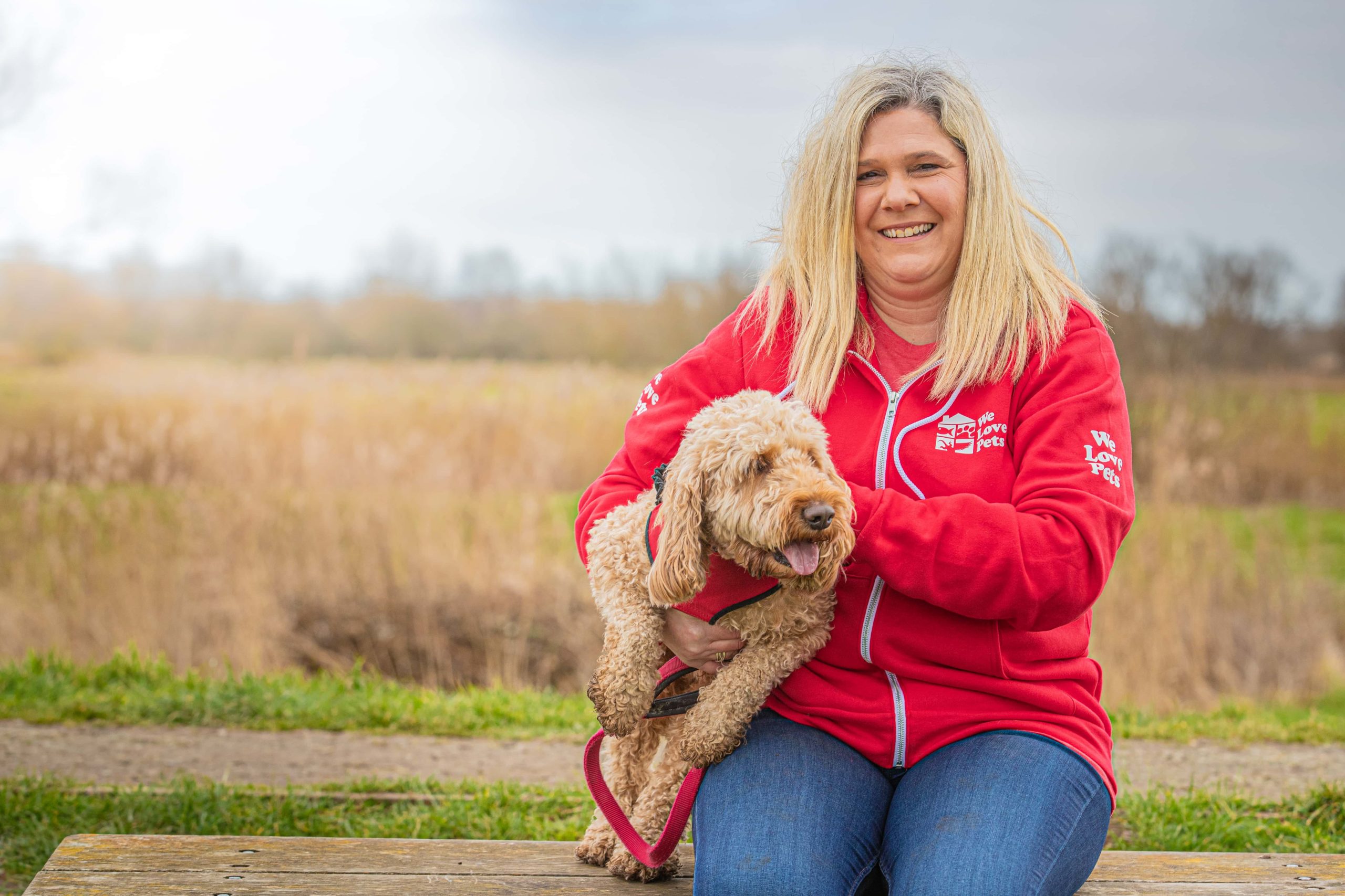 Charlotte Claydon from We Love Pets Stevenage sitting holding a dog