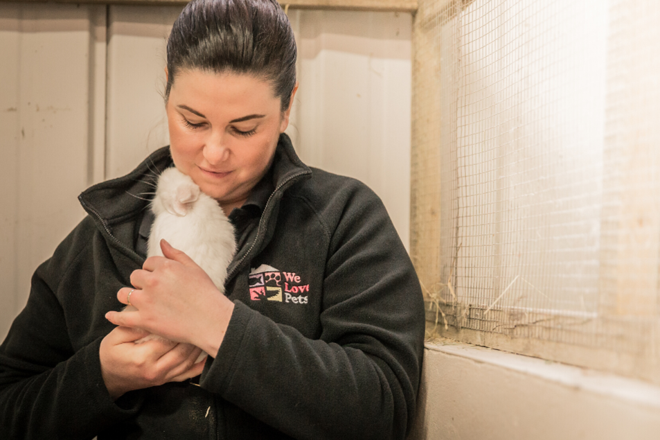 Woman from We Love Pets Blackburn holding a white rabbit