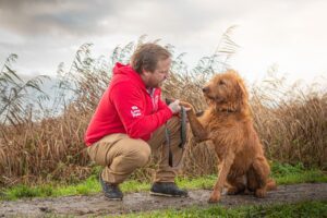 Ryan checking a dog's paw after a summer walk to help spot grass seeds.