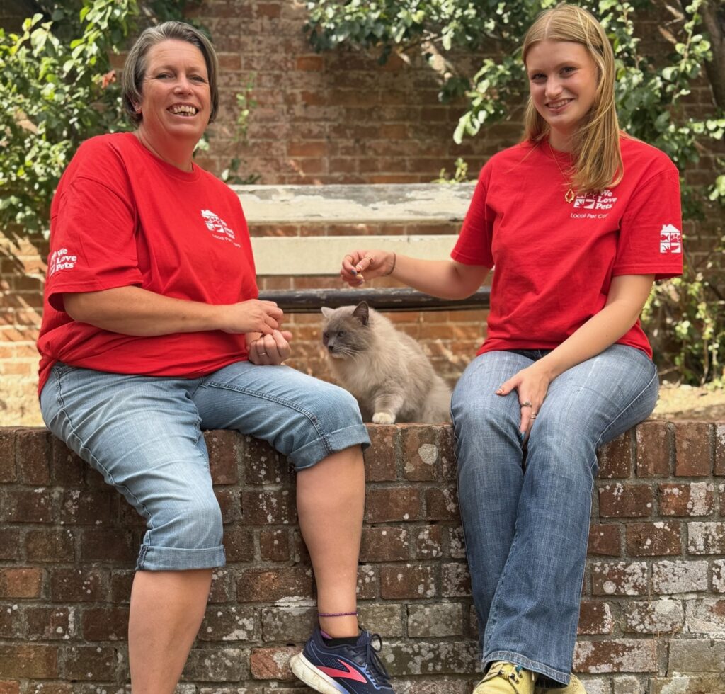 We Love Pets franchisee smiling with a cat