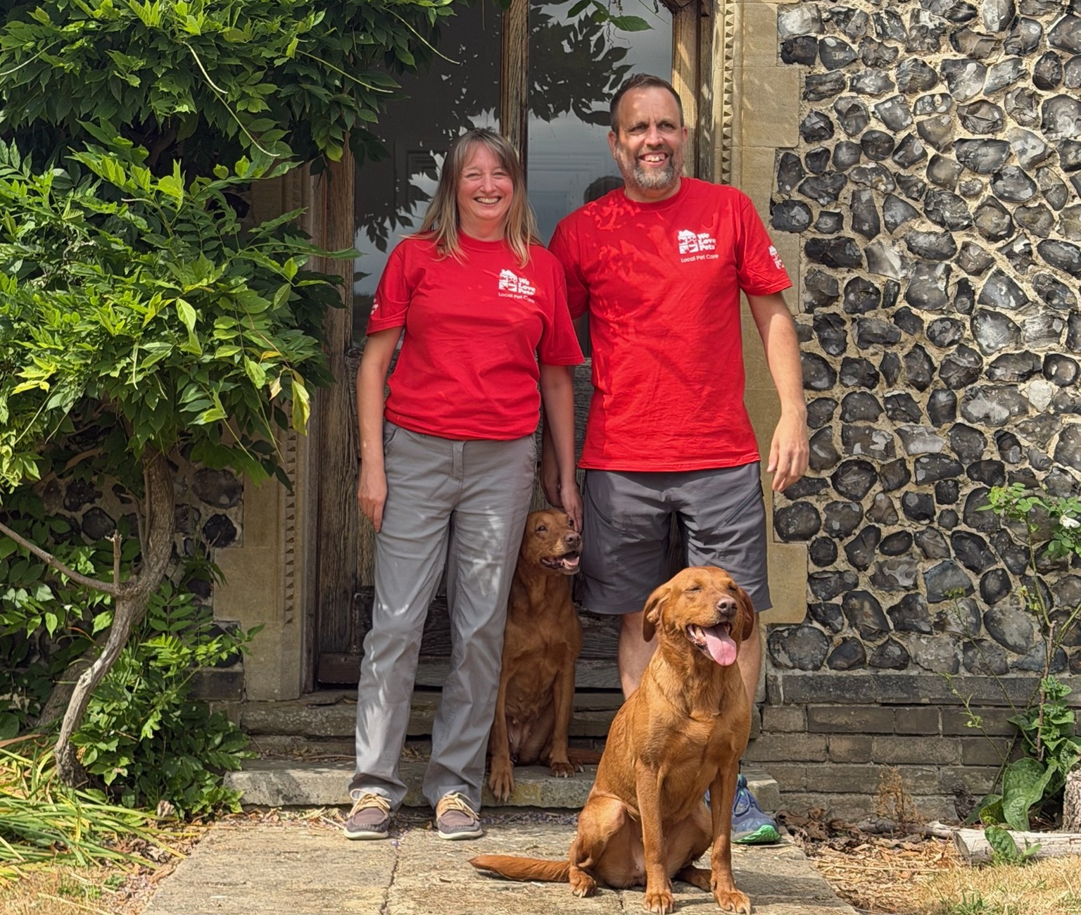 We Love Pets franchisees smiling with two dogs